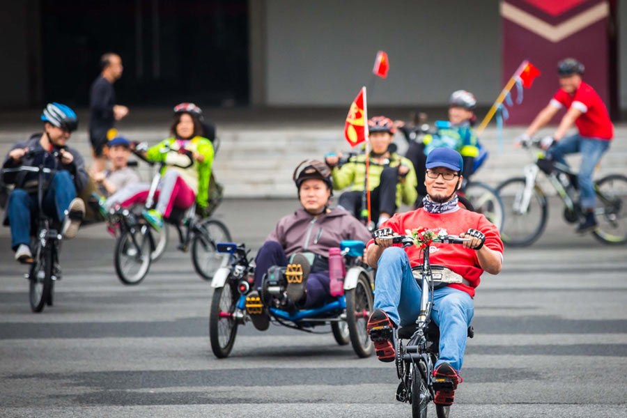 Cyclists sit back as they pedal through Guangzhou