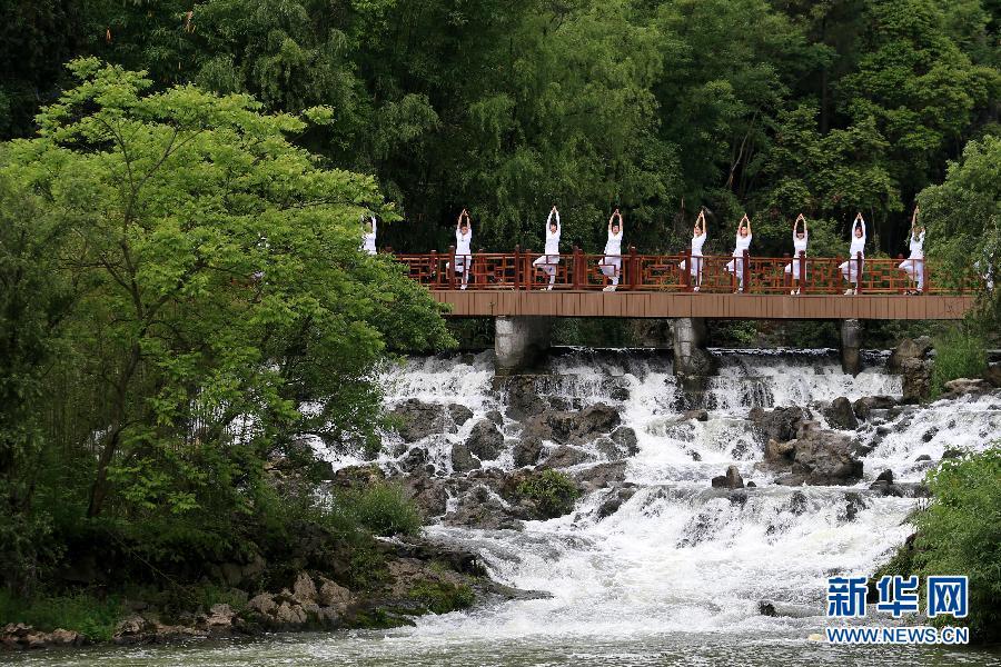 Practicing yoga among green hills and clear water