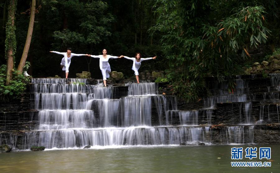 Practicing yoga among green hills and clear water