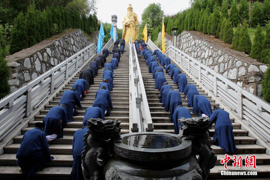 Taoist priests worship their ancestors by kneeling down on stone steps