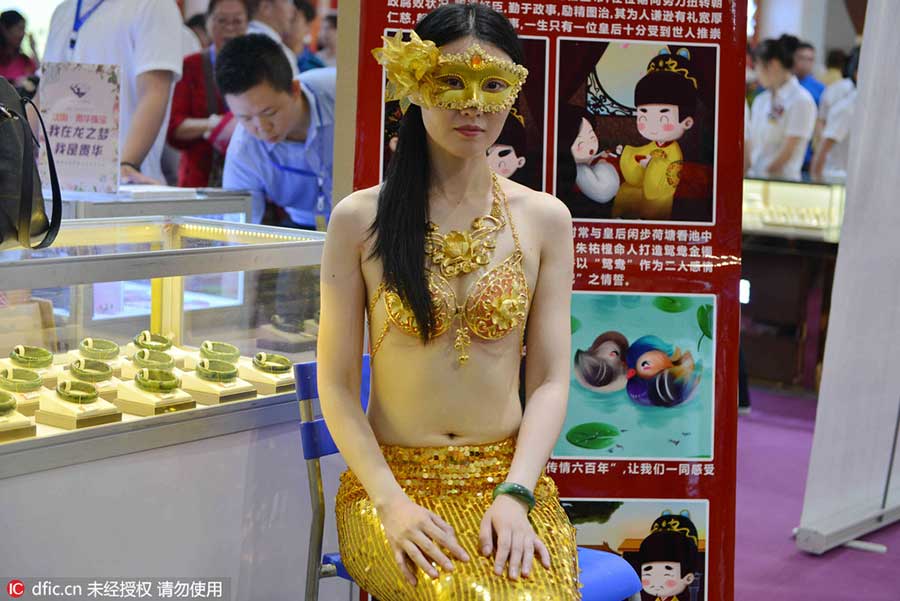 Model in golden bikini dazzles at jewelry exhibition