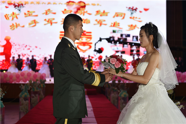 Couples exchange 'bullet shell rings' at group wedding in military camp