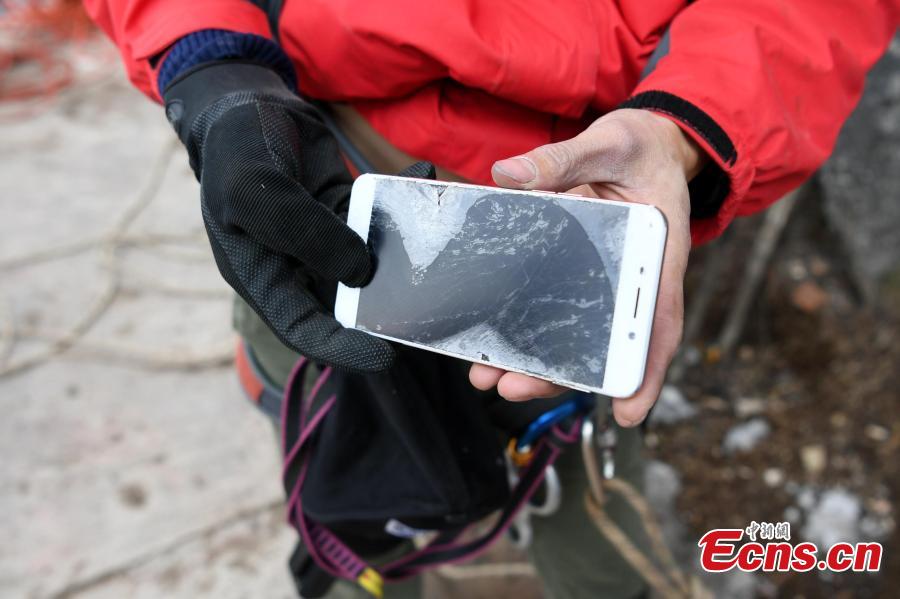 Mountain 'Spiderman' collects garbage at a cliff