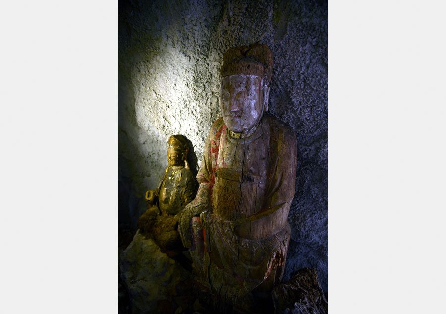 Wood sculptures discovered inside cliffside cave in Chongqing