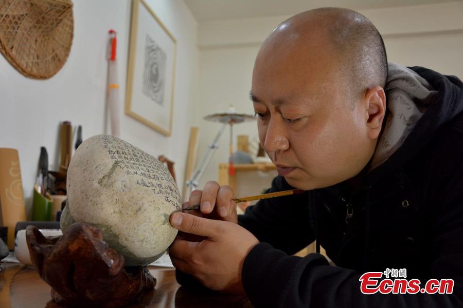 Calligrapher writes classic text on 81 stones