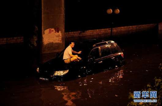 北京夜降暴雨 積水中勇現(xiàn)“淡定哥”(組圖)