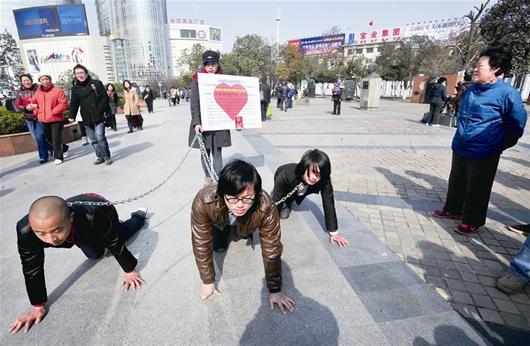 美女行為藝術(shù)用狗鏈牽3男子爬行表達(dá)反抗男權(quán)(圖)