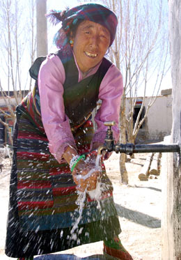 Farmer Puchi 
 washes 
 her hands with tap water outside her home in Xigaze, the Tibet Autonomous Region March 22, 2005. The central government has injected 400 million yuan in providing 500,000 Tibetans with clean drinking water since 2001. [Xinhua]