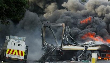 Police Service of Northern Ireland officers secure the area around a burning lorry in north Belfast, Northern Ireland, Sunday, Sep. 11, 2005. 