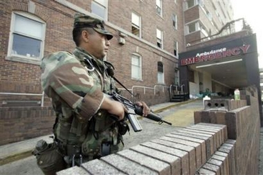 A guard keeps watch at Memorial Medical Center, Monday, Sept. 12, 2005, in New Orleans where more than 40 bodies were recovered. (AP