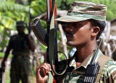 Tamil Tiger rebels hold their weapons as they keep guard outside a political office at Sampur village in Trincomalee, eastern Sri Lanka, January 20, 2006. 