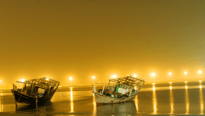 A traditional fishing boat lies at the sea-shore due to bad weather