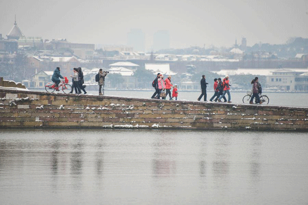 Tourists wonder by West Lake after snowfall in China's Hangzhou