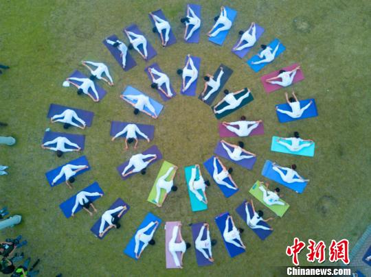 Yoga group performs lotus positions among the flowers in Wuxi