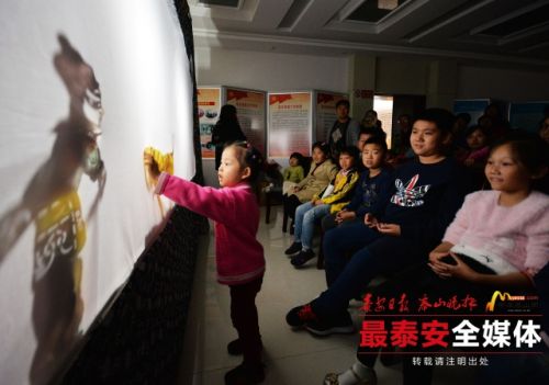 Youngsters play with puppets in Tai'an