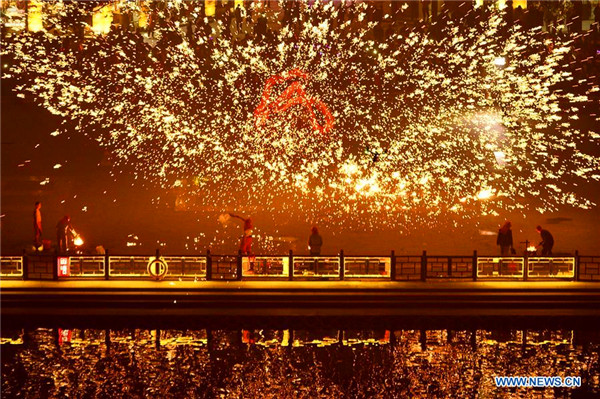 People perform fire dragon dance to welcome new year in E China town