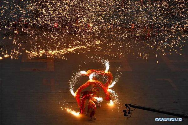 People perform fire dragon dance to welcome new year in E China town