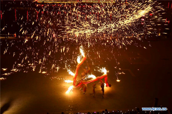 People perform fire dragon dance to welcome new year in E China town