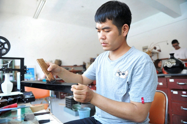 Young man polishes business with Chinese lacquerwork