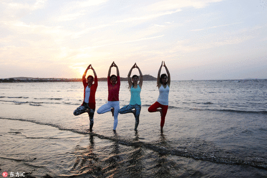 Fans practice yoga at seaside in E China