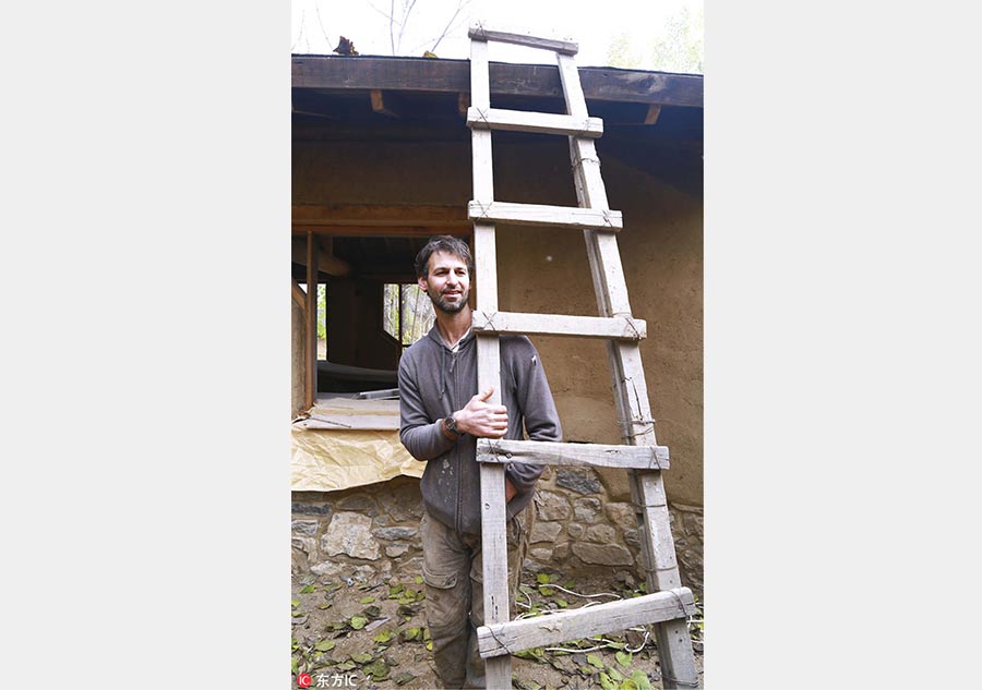 US man building mud house in rural China