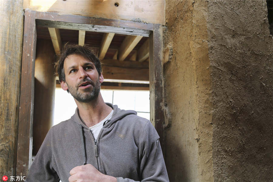 US man building mud house in rural China