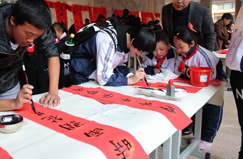 Children write couplets to welcome Spring Festival