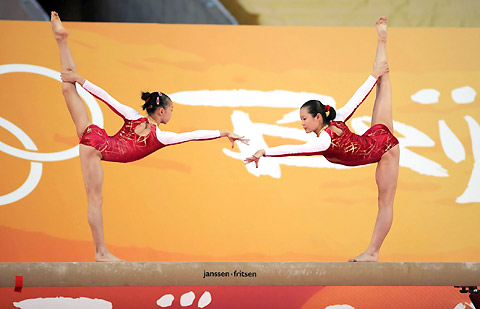 Olympic gymnastic champions Yang Yilin(L) performs on the balance beam with her teammate Cheng Fei in Hong Kong, August 30, 2008. China&apos;s Olympic gold medallists arrived in Hong Kong Friday, kicking off their three-day visit to the city.[Xinhua]