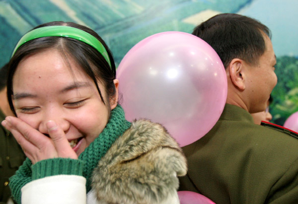 A girl and a soldier play with an air balloon during a mass match-making activity in Foshan, South China's Guangdong Province November 27 2005.