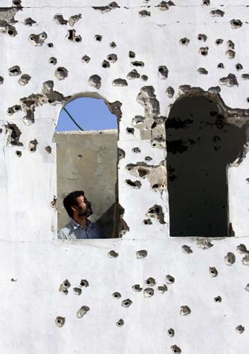 A Lebanese man surveys his house after he returns in Ghandouriyeh August 15, 2006. Thousands of displaced Lebanese headed home on Tuesday as a UN truce between Israel and Hizbollah held on into a second day and planning got under way for a beefed up U.N. force to deploy in the area. [Reuters] 