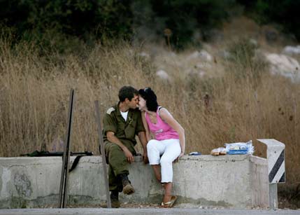 An Israeli soldier kisses his wife during the first day of ceasefire, near the town of Manara August 14, 2006. A fragile UN-ordered truce took hold in Lebanon on Monday after a month-long war between Israel and Hizbollah guerrillas. [Reuters]