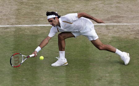 Switzerland's Roger Federer reaches to play a return to Spain's Rafael Nadal during the men's singles final at the Wimbledon tennis championships in London, July 8, 2007. 