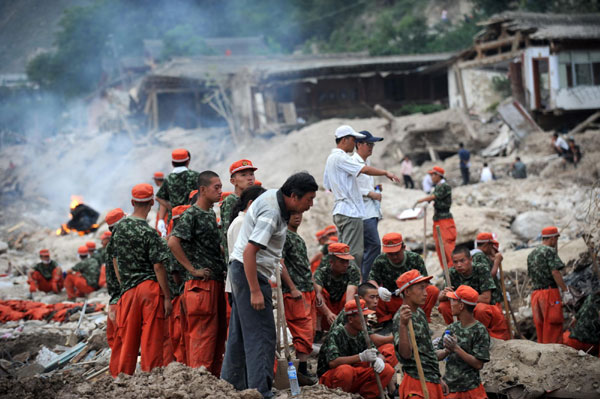 Landslide survivors waiting for families on ruins