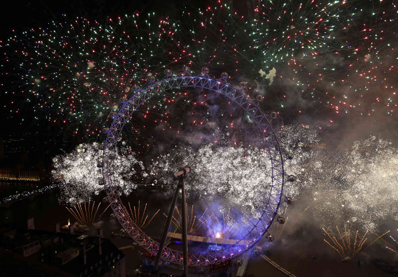 Fireworks explode around the London Eye wheel