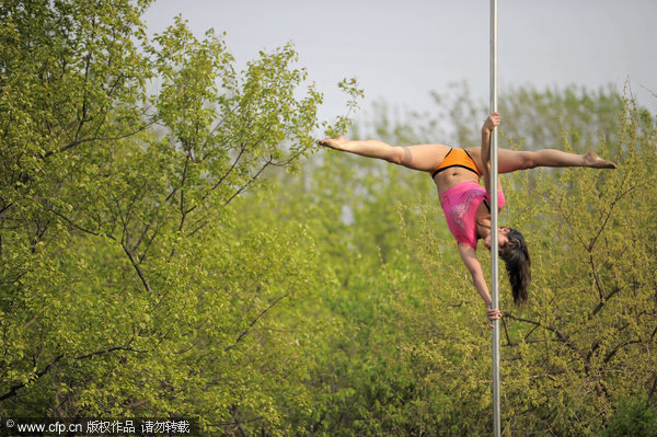 Crane hoists pole dancers in air