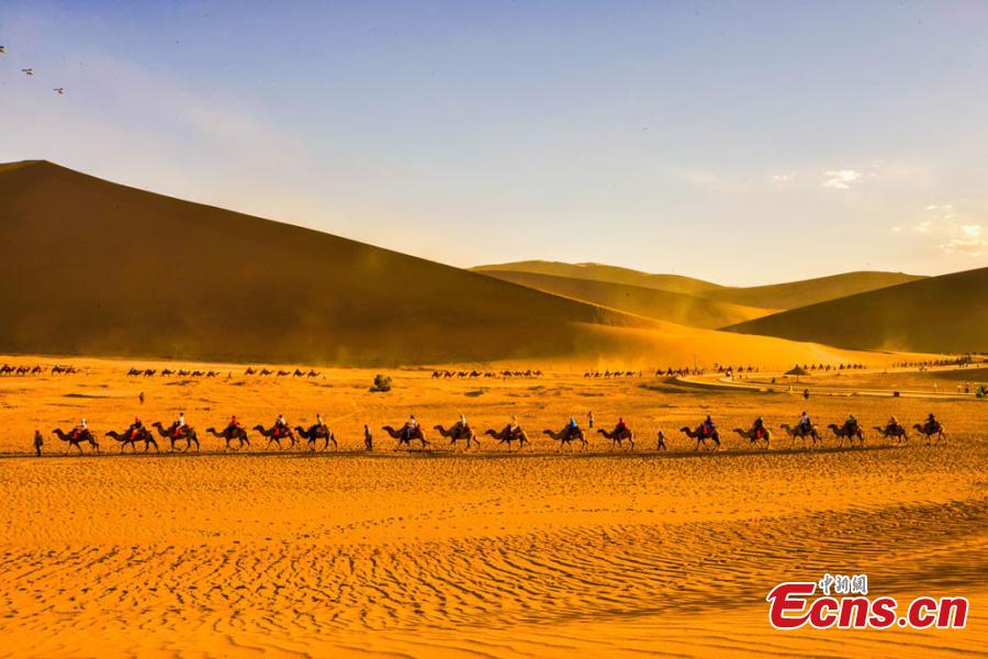 Tourists visit Mingsha Mountain in Dunhuang