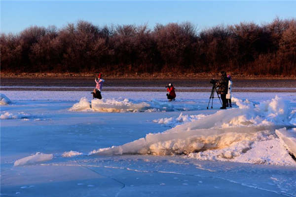 Yoga enthusiasts practice on frozen river in Heilongjiang