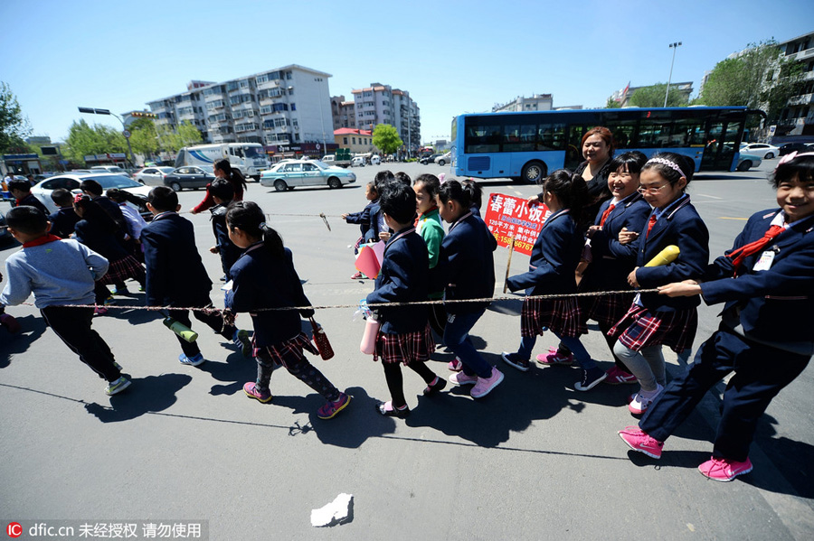 Students walk in rope circle to cross street