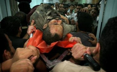 Palestinians carry the body of the Hamas government's security chief and leader of the Popular Resistence Committees, Jamal Abu Samhadana, 45, after he was killed by an Israeli airstrike late Thursday June 8, 2006. An Israeli air strike Thursday killed Samhadana, members of the group and Palestinian hospital officials said. Abu Samhadana was a key player in rocket attacks on Israel and a suspect in the fatal 2003 bombing of a U.S. convoy in the Gaza Strip. The Israeli military confirmed striking the Popular Resistance Committees camp in the southern Gaza town of Rafah, saying militants there were planning a large-scale attack on Israel. Three other people were killed and 10 were wounded by the four missiles fired at the training camp.[AP]