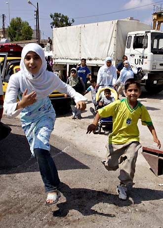 Lebanese children run from a UN truck to be evacuated to a UN boat from the southern Lebanese town of Tyre (Soure) July 20, 2006. 