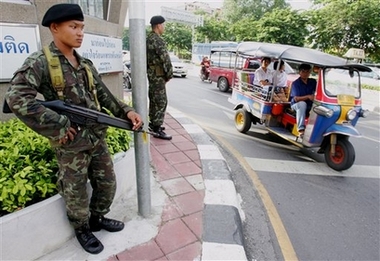 Thai soldiers stand guard on a street in Bangkok, Thailand, Thursday, Sept. 21, 2006. Bottleneck traffic returned to the streets and Thais went back to work Thursday, 36 hours after a military takeover that many in Bangkok described as the most 'friendly' coup this country has ever seen. (AP