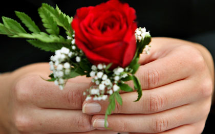 A woman holds a rose to celebrate Valentine's Day in Dubai in this February 14, 2006 file photo. Online daters, disappointed by potential partners lying about their age, weight or marital status, are turning to professional matchmakers to find love. 