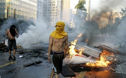 Opponents of former Gen. Augusto Pinochet stand next to burning barricades in downtown Santiago, Chile, Sunday, Dec. 10, 2006. Pinochet, who ruled Chile after a military coup from 1973 to 1990, died Sunday from heart complications. He was 91. (AP