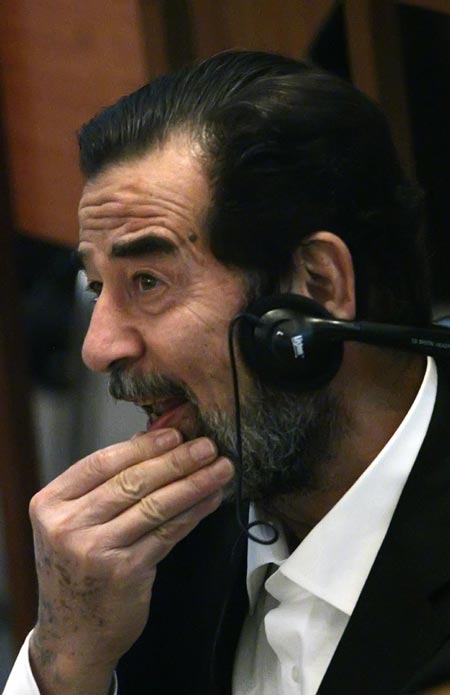 Ousted Iraqi leader Saddam Hussein, wearing headphones for translation, listens to witness testimony during his trial held in Baghdad's heavily fortified Green Zone October 18, 2006.