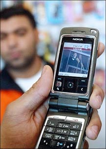 An Iraqi watches video footage of the execution of ousted leader Saddam Hussein on a mobile phone at a shop in central Baghdad. Euphoric mobile telephone users from Baghdad's Sadr City were gleefully sharing copies of a grainy video showing former dictator Saddam Hussein's execution by hanging.(AFP