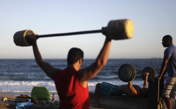 Men work out using cement-made weights